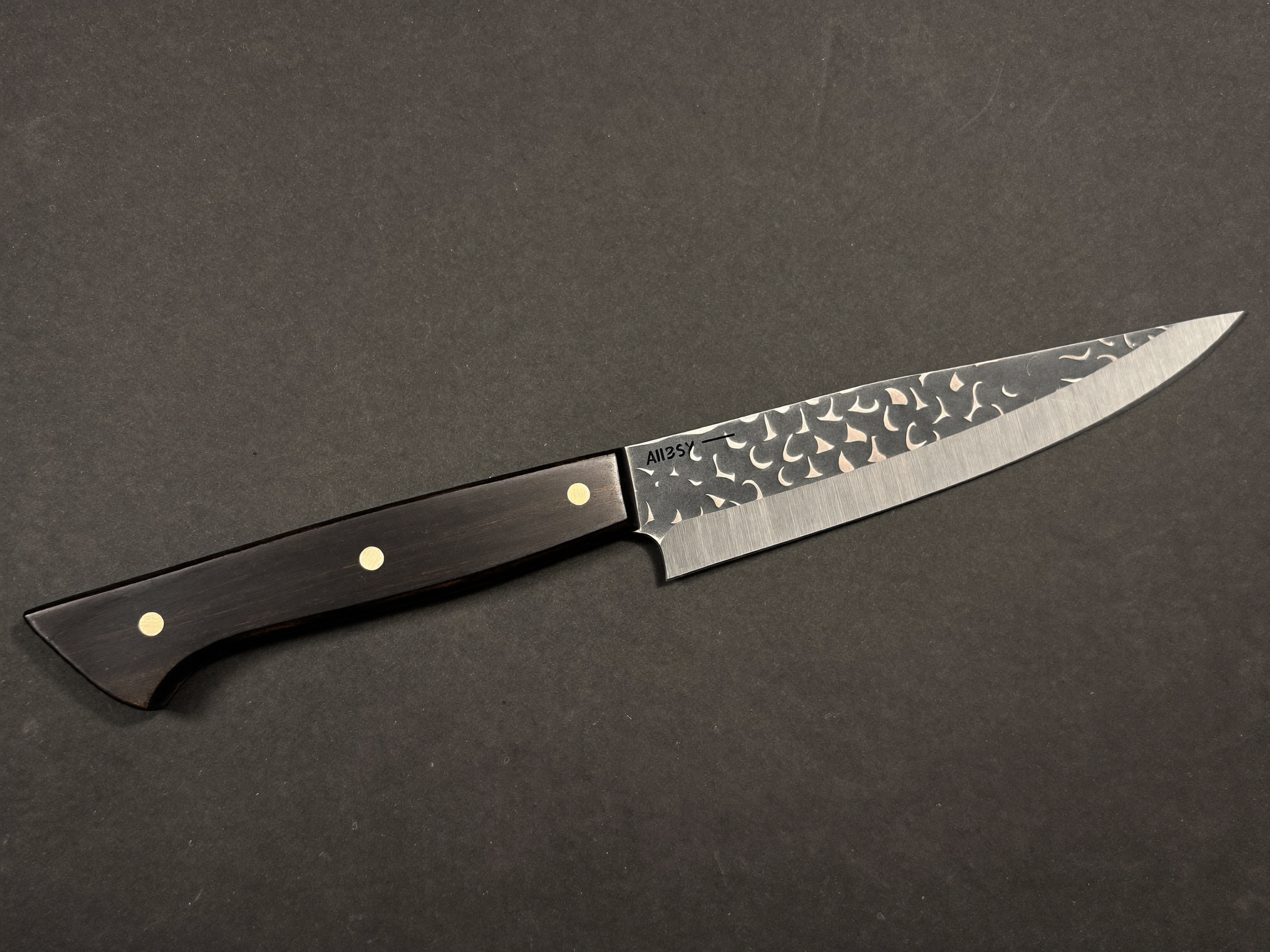 Sharpening a Damascus kitchen knife with a whetstone